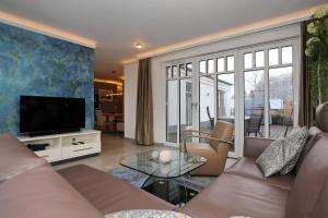 ein Wohnzimmer mit einem Sofa und einem TV in der Unterkunft Linden-Palais Wohnung 33 in Heiligendamm