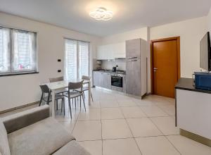 a kitchen and living room with a table and chairs at Nuovo bilocale nel porto antico in Savona