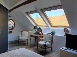 - une chambre avec un bureau, 2 chaises et une fenêtre dans l'établissement Maison Bélénos, à Nevy-sur-Seille