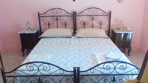 una camera da letto con un grande letto con due comodini di Casetta Stellata Monteforte a Casarano