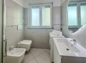 uma casa de banho branca com um lavatório e um WC em Nuovo bilocale nel porto antico em Savona