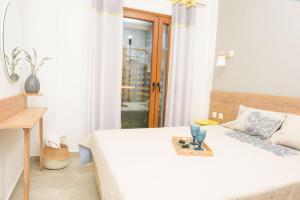 a bedroom with a white bed with a tray on it at Στ' ακρογιάλι in Nea Roda