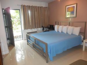 um quarto com uma cama grande e um cobertor azul em Shalimar Motel em Miami