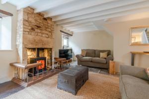 a living room with a fireplace and a couch at Farthingdales in Burford