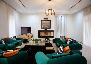馬拉喀什的住宿－DAR JMEL，客厅设有绿色沙发和壁炉