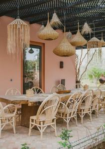 una sala da pranzo con un lungo tavolo e sedie di DAR JMEL a Marrakech