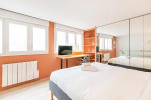 a bedroom with two beds and a desk with a computer at Les Nuances de Julien - Appt au coeur de Nancy in Nancy