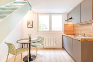 una cocina con mesa y sillas y una escalera en Les Nuances de Julien, en Nancy