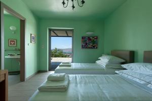 um quarto com 3 camas e vista para o oceano em Montofoli Wine Estate em Caristo