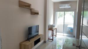 曼谷的住宿－Firstbuild Apartment (เฟิร์สบิวท์อพาร์ทเม้น)，客厅设有壁挂式平面电视。