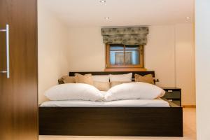 a bedroom with a bed with white pillows and a window at Alpine Lodge Sölden - Chalet in Sölden