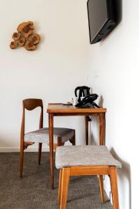 stół z krzesłem oraz biurko z telewizorem w obiekcie HOTEL LE 25 w mieście Andernos-les-Bains