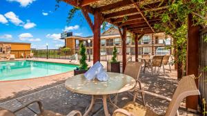a patio with a table and chairs next to a pool at Best Western El Reno in El Reno