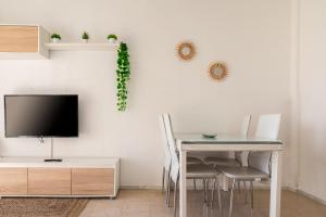 a dining room with a tv and a table with chairs at Apartamento Consul Park in Blanes