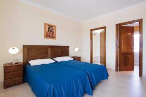 プラヤ・ブランカにあるBrenasのベッドルーム1室(青いベッド1台、ランプ2つ、ドア付)
