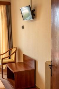 a room with a desk and a tv on the wall at Telis Hotel in Aigio