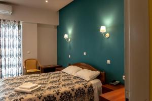 a bedroom with a bed and a green wall at Telis Hotel in Aigio