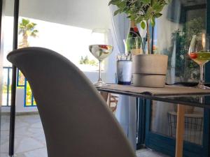 un tavolo con due bicchieri di vino e una sedia di Minimal Resort with Pool in Siviri, 150m from the Sea a Siviri Altre 37 foto