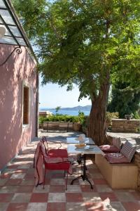 un patio con mesa y sillas bajo un árbol en Montofoli Wine Estate, en Caristo