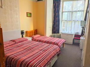 a hotel room with two beds and a window at Altavia Hotel in Sandown