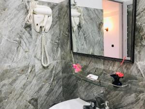 bagno con lavandino, specchio e telefono di Heaven Breeze a Kandy
