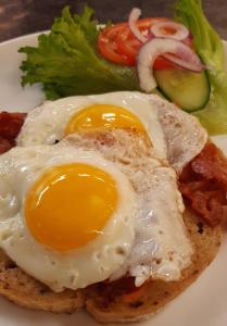 a fried egg on a piece of bread with bacon and vegetables at Saltdal Turistsenter in Storjord