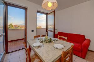 comedor con mesa y sofá rojo en Il Riflesso sul Lago en Manerba del Garda