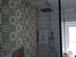 a bathroom with a shower and a tile wall at Large 4 Bedroom House in Norfolk Perfect for Families and Groups of Friends in Stoke Ferry