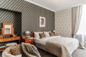 una camera con letto, sedia e specchio di Hotel H15 Francuski Old Town a Cracovia