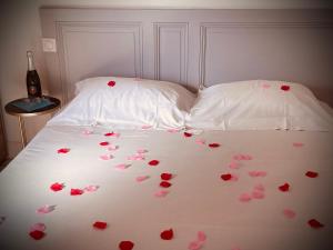 a white bed with pink hearts on it at MAISON MIGNARDISE - Cité in Carcassonne