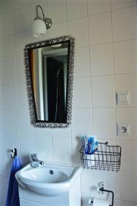 baño con lavabo y espejo en la pared en KukuRyku Zagroda Wiejska nad Bugiem, en Osłowo