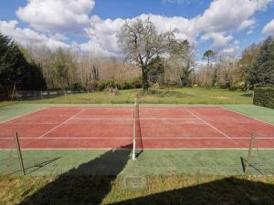 a tennis court with a net on a field at maison de vacances Mont de Marsan in Lucbardez-et-Bargues