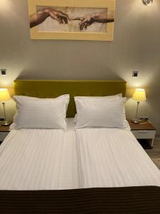 a large white bed with two pillows in a room at Silver Luxury 6 in Poiana Brasov