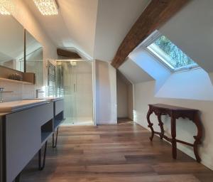 an attic kitchen with a skylight and a wooden floor at Maison Bélénos in Nevy-sur-Seille