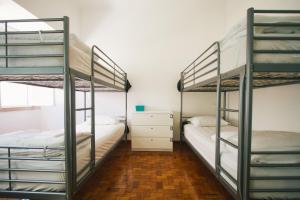 a bedroom with two bunk beds and a dresser at PTM DownTown Hostel&Suites in Portimão