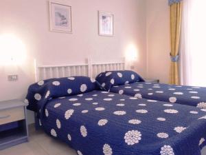 a bedroom with a bed with a blue and white comforter at Royal Golf Park Club in San Miguel de Abona