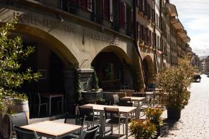 Un grupo de mesas y sillas fuera de un edificio. en Goldener Schlüssel, en Berna