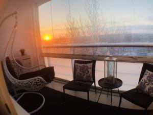 um quarto com uma janela com cadeiras e uma mesa em Modern design w/balcony, free parking,WiFi & A/C em Lappeenranta