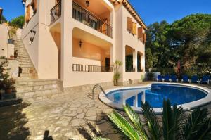a house with a swimming pool in front of it at Villa Victoria in Lloret de Mar