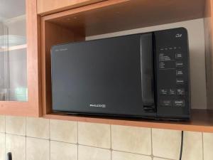 a black microwave oven in a kitchen at Gray House Apartmán in Zlaté Hory