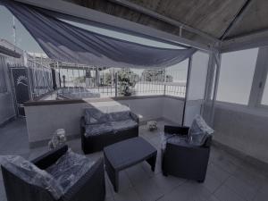 a balcony with chairs and a bed and a table at Casa vacanza Leone con Terrazza in Ginosa Marina