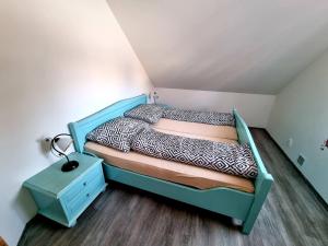 - une petite chambre avec un lit et une table de chevet dans l'établissement Dům a chatka pod Smrkem, à Nové Město pod Smrkem