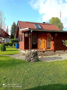 a small wooden house with a grass yard at Dům a chatka pod Smrkem in Nové Město pod Smrkem