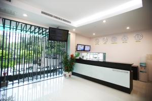 a lobby with a reception desk and a large window at Pattara Place in Chiang Mai