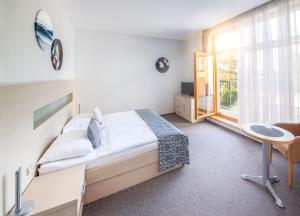 una camera da letto con un letto, una scrivania e una finestra di Hotel U Pramenu a Plzeň