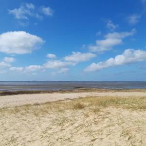 einen Sandstrand mit dem Ozean im Hintergrund in der Unterkunft Ferienwohnung Strandnah in Cuxhaven