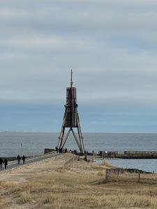 a wooden structure on a beach near the water at Ferienwohnung Strandnah in Cuxhaven