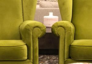 a bathroom with two green chairs and a white vase at Hotel San Giorgio in Fiuggi