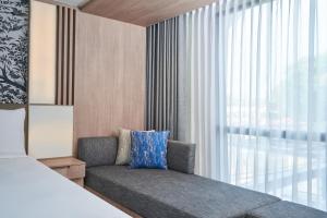 una camera da letto con divano e finestra di Courtyard by Marriott North Pattaya a Pattaya North
