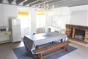 cocina con mesa y chimenea en Du Vignoble à l'Atlantique - Château Cassemichère gîte, en La Chapelle-Heulin